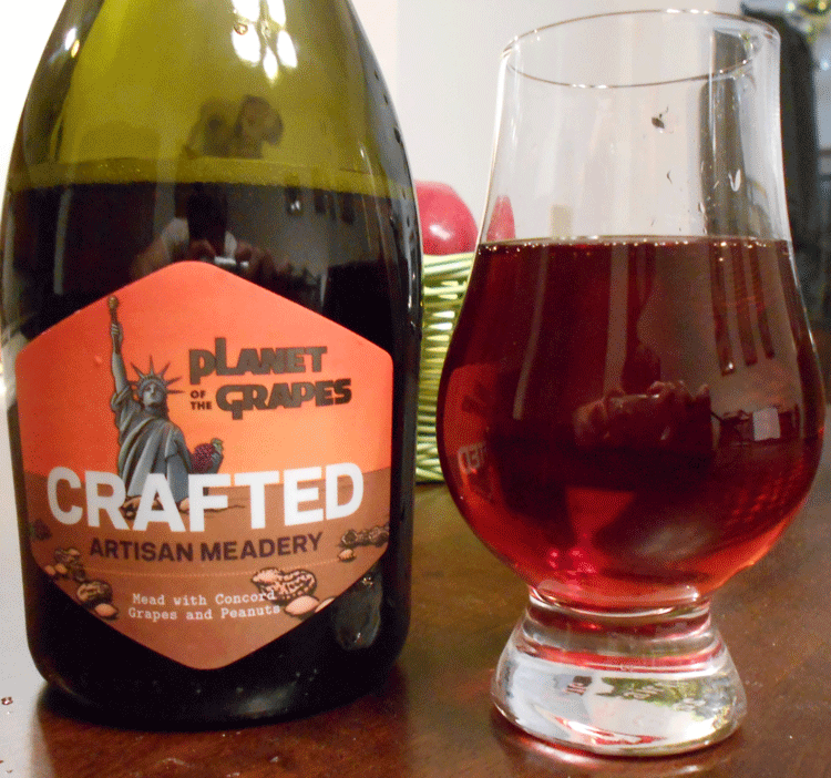 Planet of the Grapes Mead in glass next to bottle